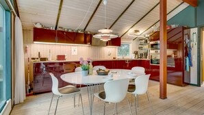 A modern kitchen with a dining area, wooden flooring, and a ceiling with exposed beams. - "Nikoletta" - 150m from the sea by Interhome (Fjerritslev)