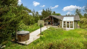 A cabin with a deck, a hot tub, and a patio area. - "Nikoletta" - 150m from the sea by Interhome (Fjerritslev)
