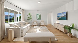 Ein modernes Wohnzimmer mit einer Couch, zwei Sesseln, einem Couchtisch, einem Fernseher und einer Pflanze.