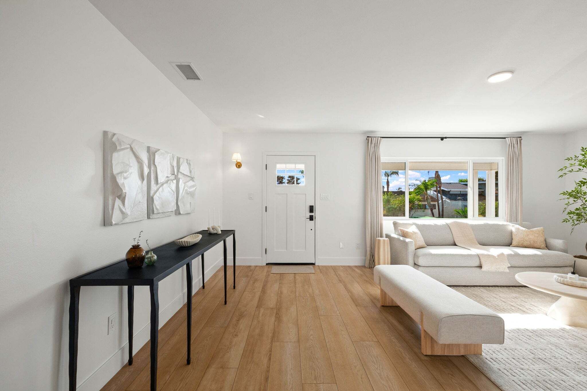 A modern living room with a sofa, a coffee table, and a dining table with chairs.