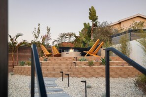 Un patio con un hogar, sillones y un muro de ladrillo.