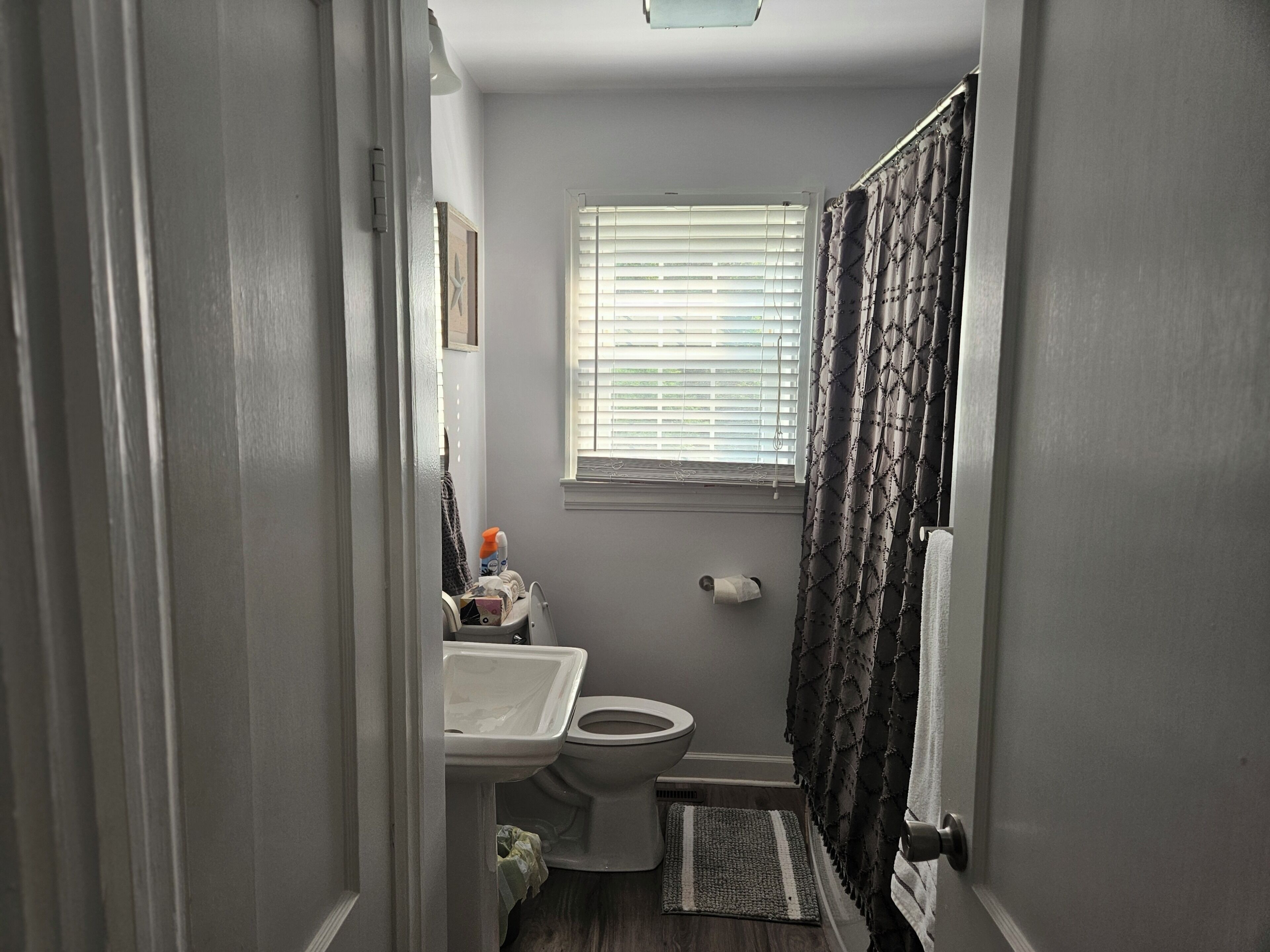A compact bathroom with a toilet, sink, and window.