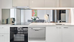 Uma cozinha moderna com máquina de lavar louça, forno e fogão embutido.
