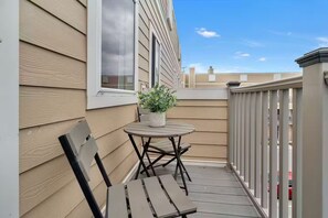 A wooden deck with a table and chairs, a potted plant, and a view of the sky. - The Swiftie: Sleeps 5, Pool, City & River Views, Near Broadway (Nashville)
