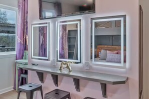 A room with a large window, a desk with a computer, and a bed with pillows. - The Swiftie: Sleeps 5, Pool, City & River Views, Near Broadway (Nashville)