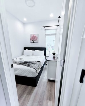 Ein modernes Schlafzimmer mit Bett, Nachttisch und einem Bild an der Wand.