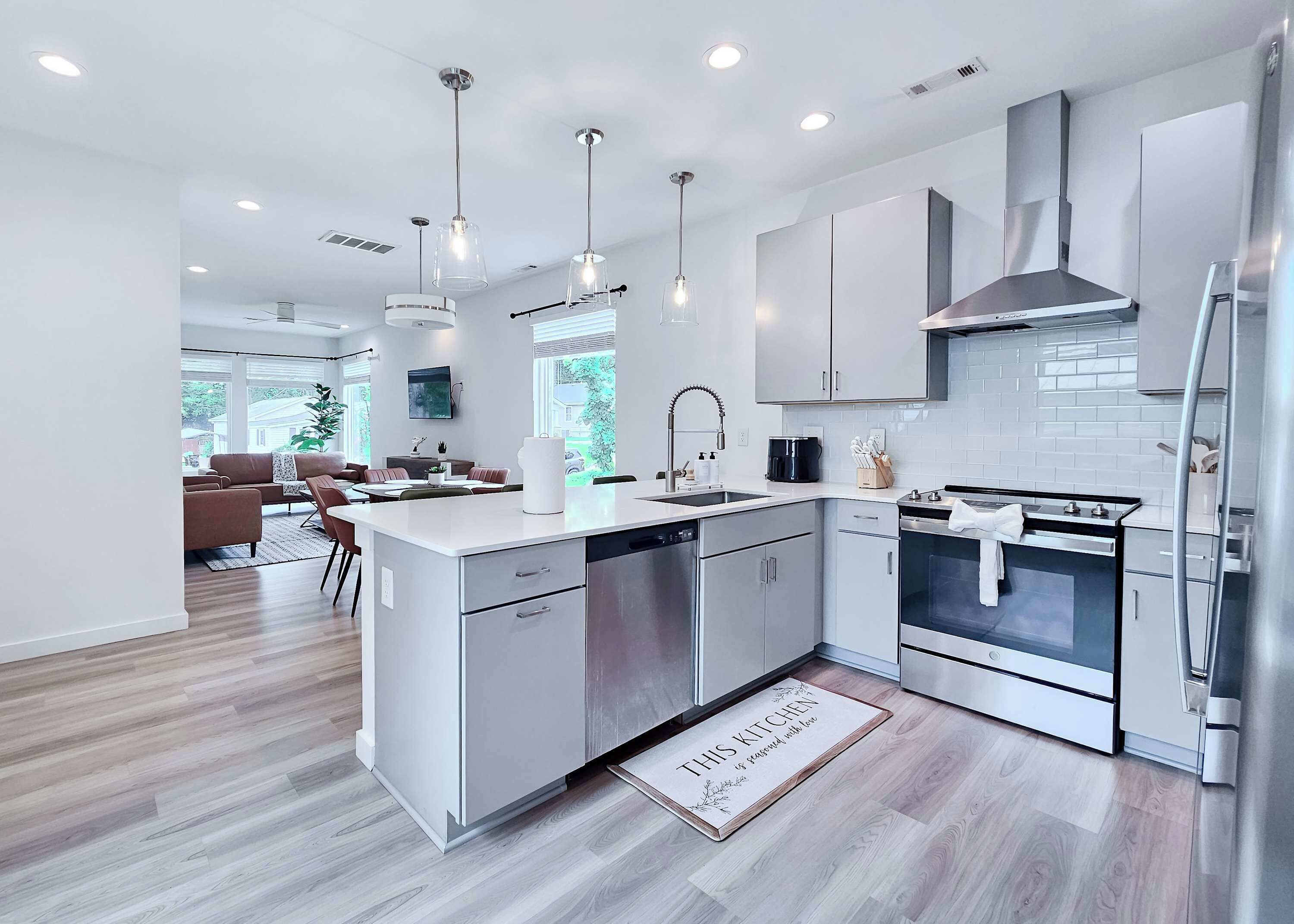 A modern kitchen with a central island, stainless steel appliances, and pendant lighting.
