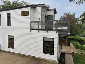 Ein modernes, zweistöckiges Haus mit Balkon, großen Fenstern und Garage.