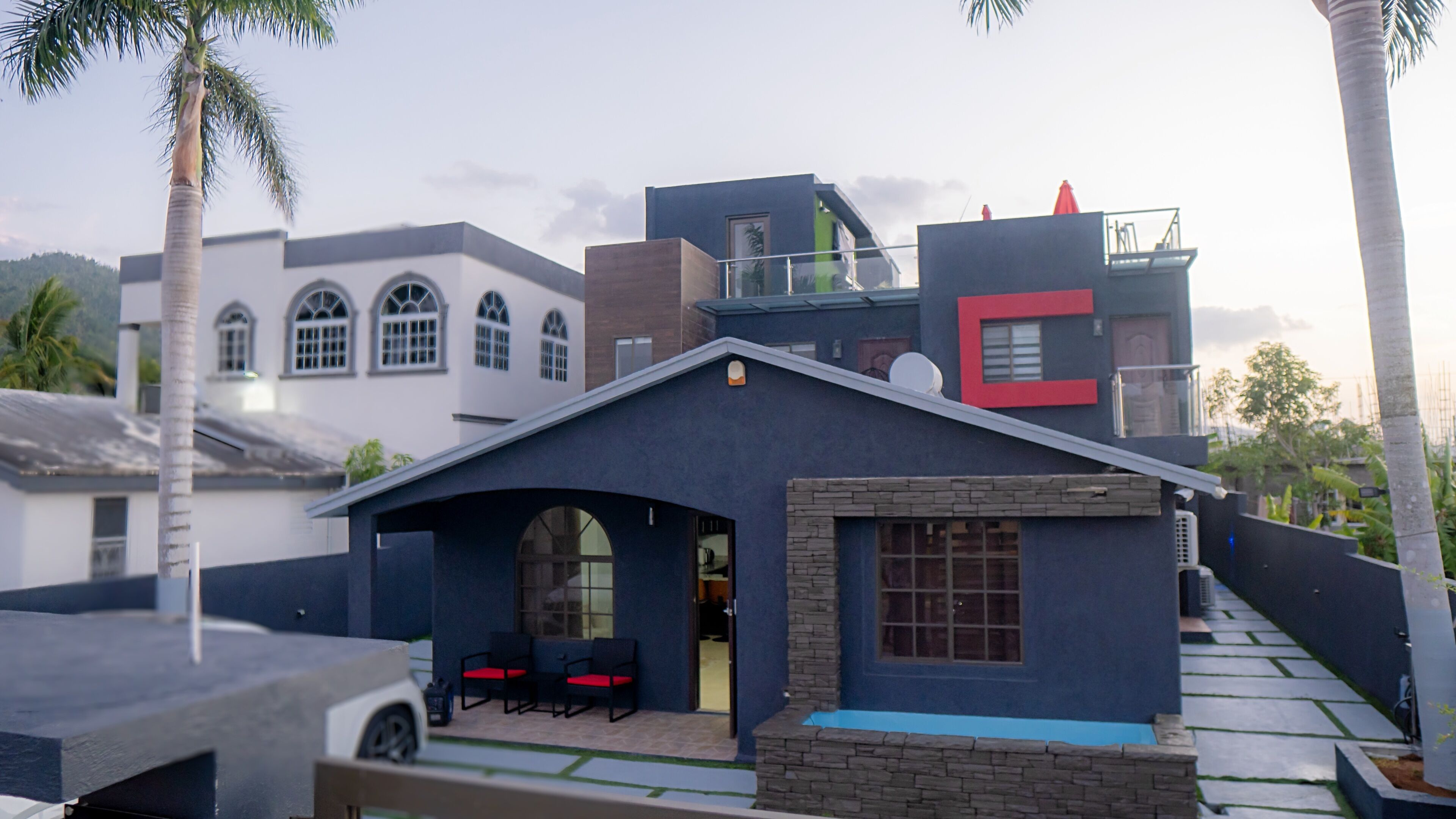 Een modern huis met een overdekt terras, een garage en een stenen open haard.