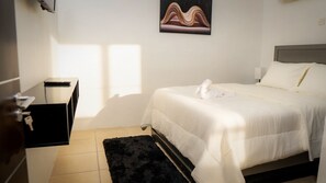 Ein Hotelzimmer mit einem Bett, einem Schreibtisch, einem Sessel und einem Bild an der Wand.