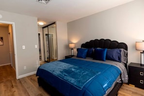 A bedroom with a bed, bedside tables, and a mirror. - Modern Pet-Friendly 2BR | Near Strip & Chinatown (Las Vegas)