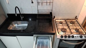 Una cocina con un lavaplatos de acero inoxidable, una estufa y un horno empotrado.