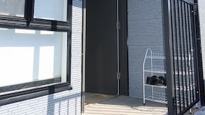 En modern byggnad med en fasad av tegel, ett stort fönster och ett metallräcke.