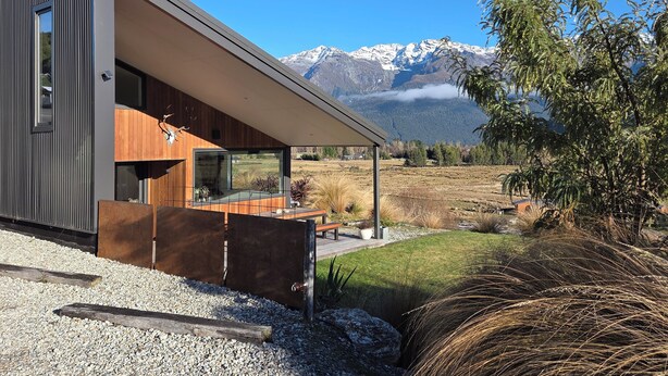 A modern house with a large glass window, wooden interior, and a view of mountains. - Alpine Home Escape | Hot Tub & Mountain Views | Glenorchy (Glenorchy)