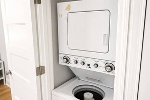 A compact, white, wall-mounted washer and dryer unit with multiple control knobs and settings. - Private Cozy Retreat,1GB Fiber WiFi, Near Downtown (Austin)