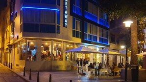 En modern byggnad med en skylt som visar ordet ”GETAWAY”, utomhusplatser och ett stenbelagt område.