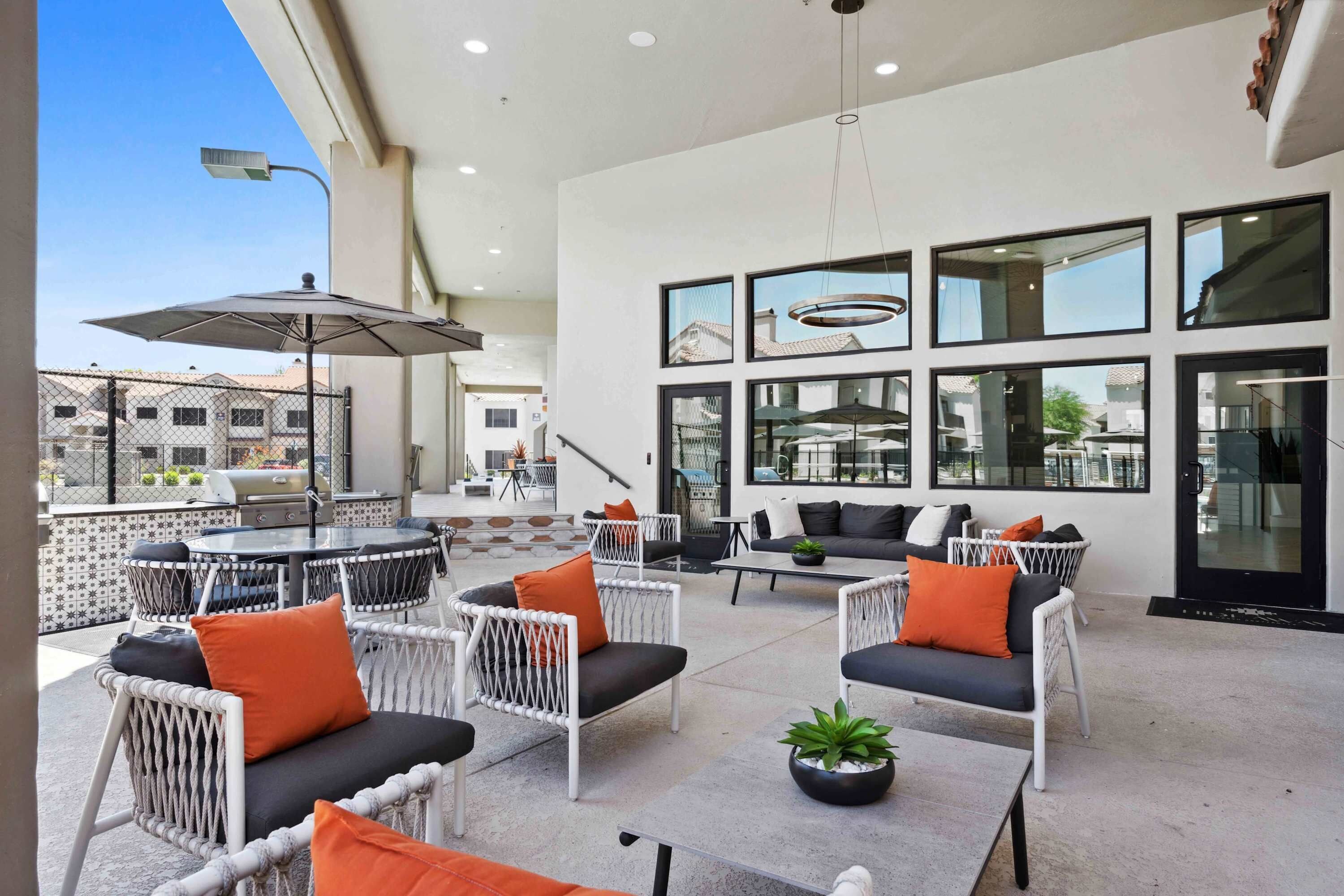 Un patio al aire libre con disposición de asientos, una parrilla y vistas de la ciudad.