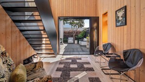 Ein modernes Interieur mit Treppe, Sitzgelegenheit und Blick ins Freie.