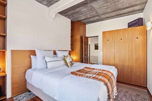 A hotel room with a bed, a wardrobe, a radiator, and a wooden headboard. - The Sumner Escape - Sleeps 5, Walk to Beach (Christchurch)