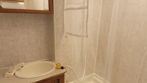 A bathroom with a wooden vanity, a bathtub, and a shower enclosure.