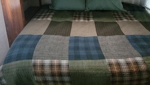 A bunk bed with a checkered quilt and two pillows.