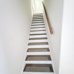 A staircase with white steps and a wooden handrail. - Beautifully Renovated 3-Bedroom Home Minutes from Downtown Atlanta (Atlanta)