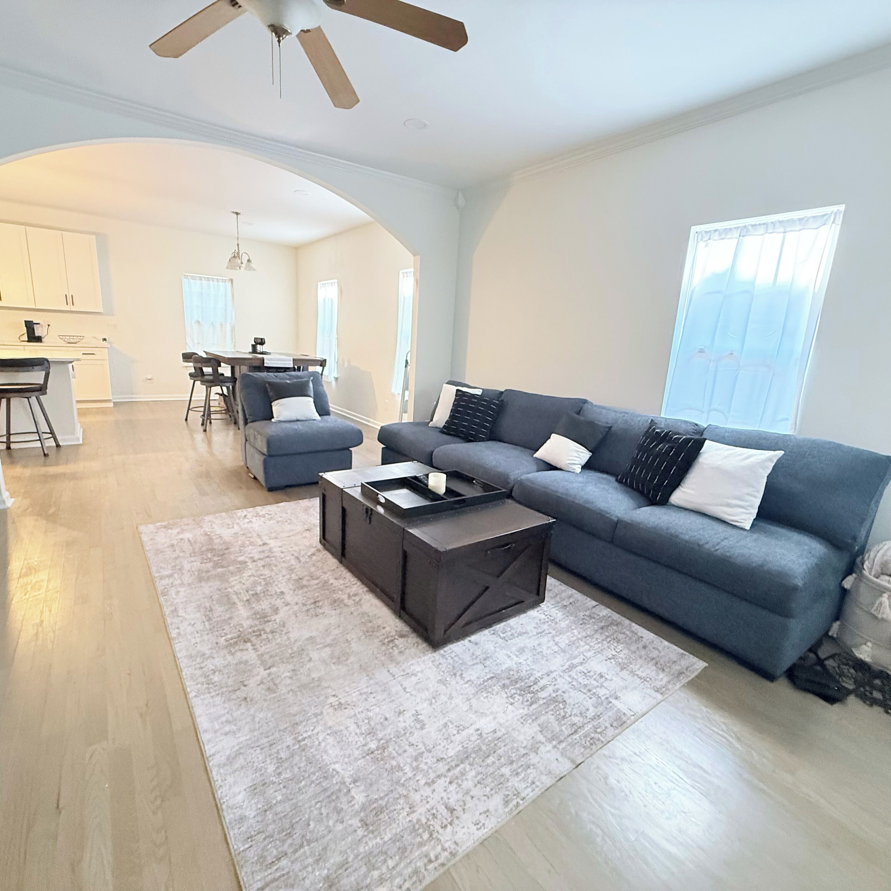 Ein geräumiges Wohnzimmer mit Sofa, Couchtisch und einem Essbereich im Hintergrund.