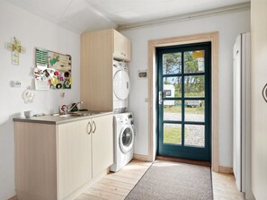 Ein Waschraum mit Waschmaschine, Trockner, Spüle und Schrank.