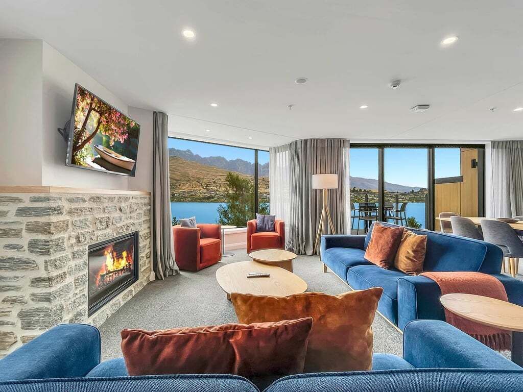 Uma sala de estar espaçosa com lareira, assentos confortáveis e uma janela grande com vista panorâmica.