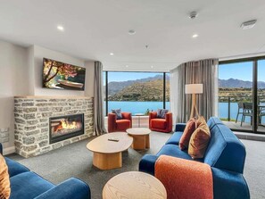 Uma sala de estar moderna com lareira de pedra, assentos confortáveis e uma janela grande com vista panorâmica.