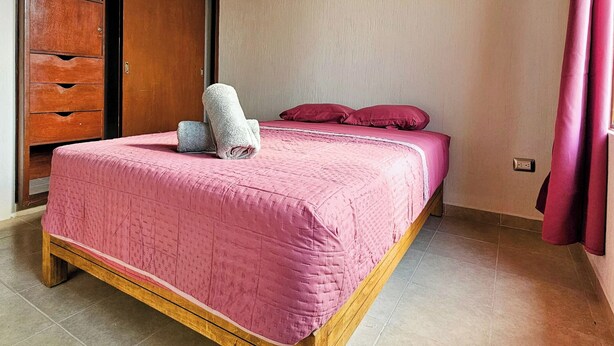 A bedroom with a bed, wooden wardrobe, and a ceiling light fixture. - Accommodations Near Spas (Ixmiquilpan)