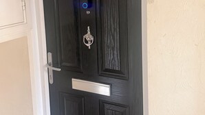 Une porte noire portant le numéro 31, une poignée argentée et un indicateur lumineux bleu.