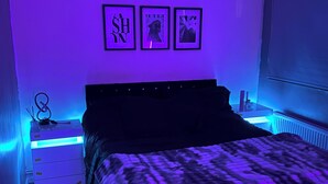 Une chambre à coucher avec un lit, des tables de chevet et des œuvres d’art murales.