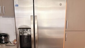 Een roestvrijstalen koelkast met waterdispenser, een ingebouwde ijsmachine en een vriesvak.