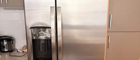 A stainless steel refrigerator with a water dispenser, a built-in ice maker, and a freezer compartment.