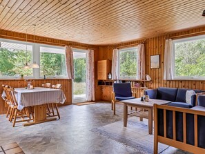 A wooden interior with a dining area, seating, and large windows. - "Iivo" - 3.5km from the sea by Interhome (Rømø)