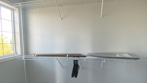 Een kamer met een inbouwkast, een raam en een vloerbedekking.