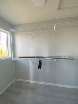 Ein Zimmer mit eingebauter Regaleinheit, einem Fenster und einem Teppichboden.