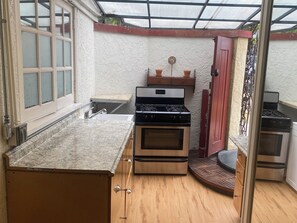 A compact kitchen with a gas stove, oven, and sink.