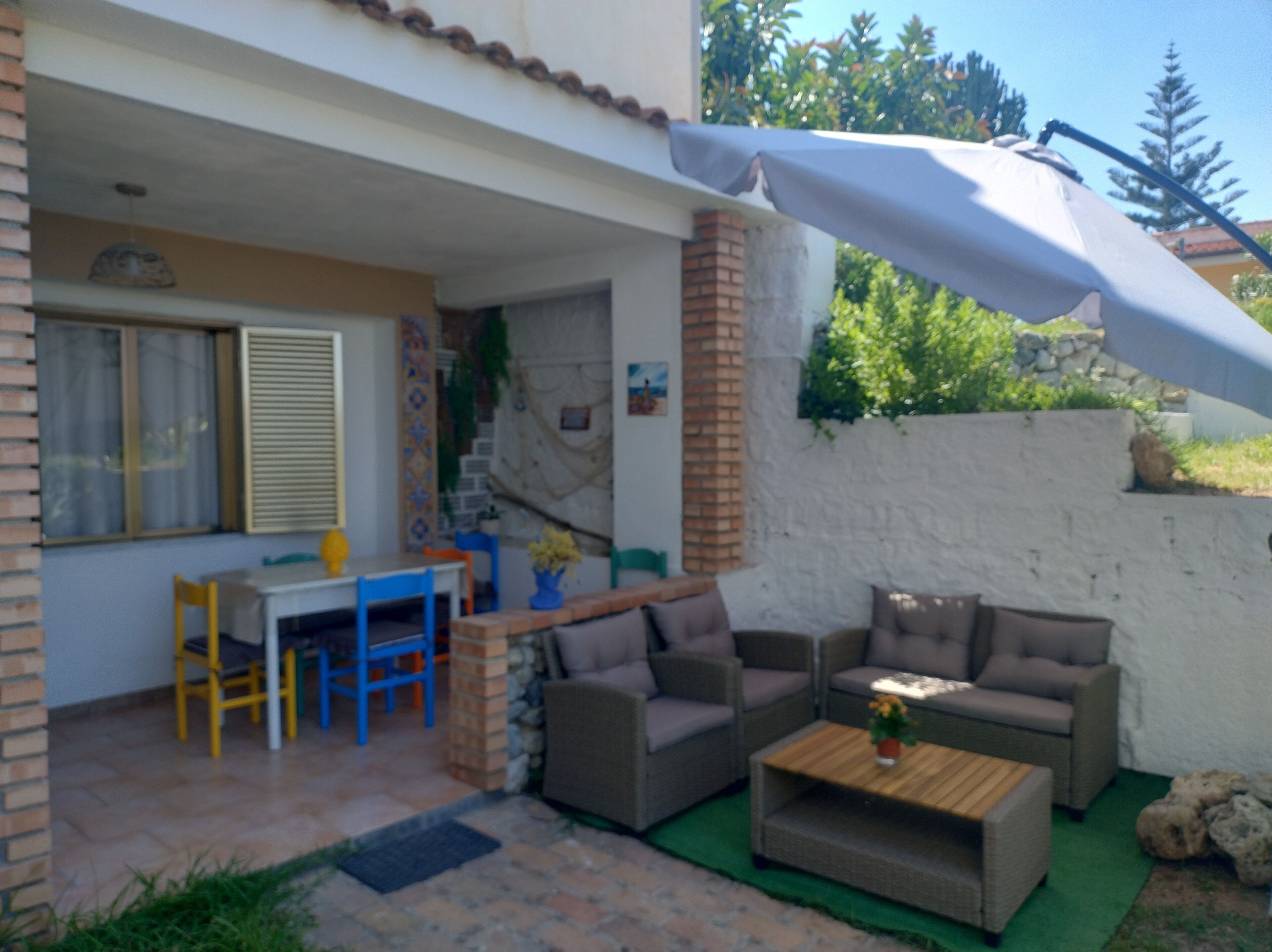 An outdoor patio with a table and chairs, a sofa, and a coffee table.