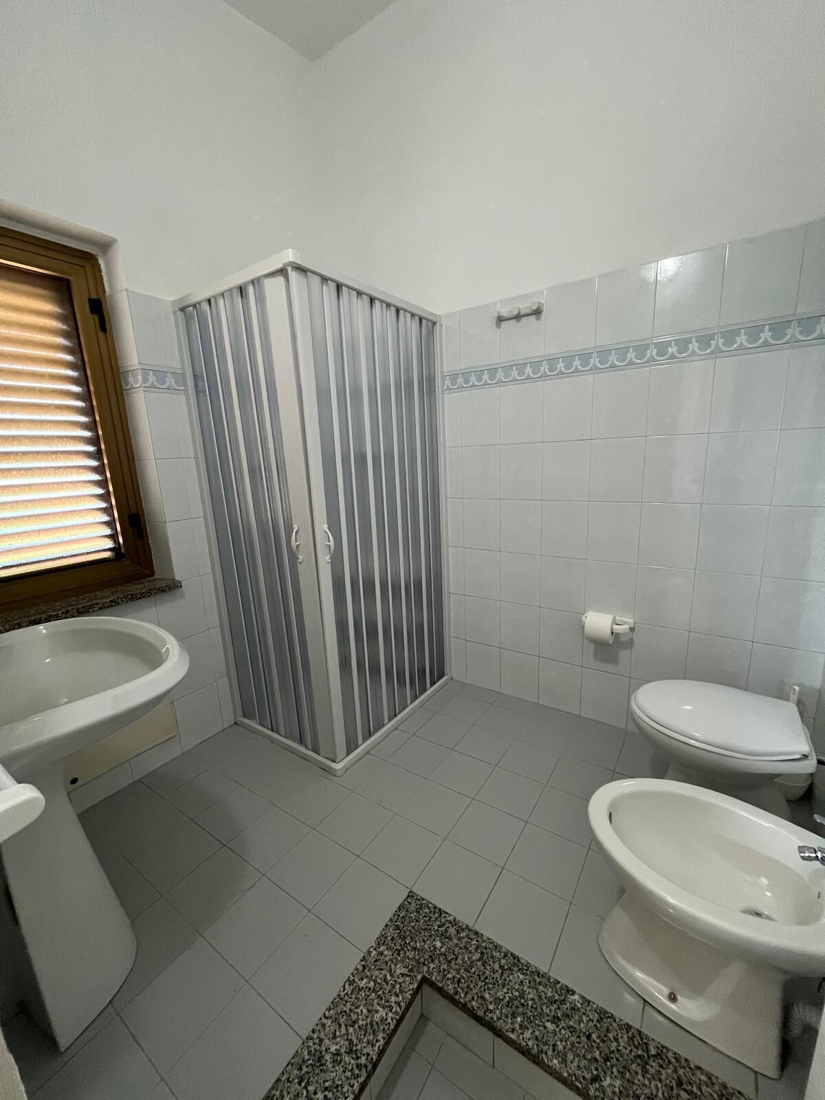 Un baño con ducha, inodoro, bidé y lavamanos.