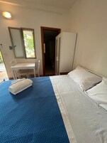 Un dormitorio con cama, escritorio y espejo.