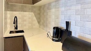 A kitchen with a white countertop, a black faucet, and a black coffee maker. - Bright Kalkallo Home, Easy Melbourne Access (Kalkallo)