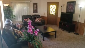 Una sala de estar con sofá, mesa de centro y televisor.