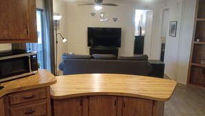 Una cocina con microondas, armarios de madera y encimera.