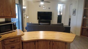 A kitchen with a microwave, wooden cabinets, and a countertop. - Charming 55+ Arizona Getaway (Mesa)