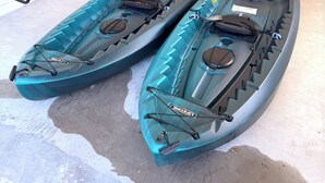 Two kayaks in a garage with a ladder, a basketball, and a vacuum cleaner in the background. -     Coastal Retreat with Pool, Games & Free Kayaks (Sebastian)