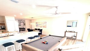 A pool table with balls, a dining area with chairs, and a kitchen area with a coffee machine. -     Coastal Retreat with Pool, Games & Free Kayaks (Sebastian)