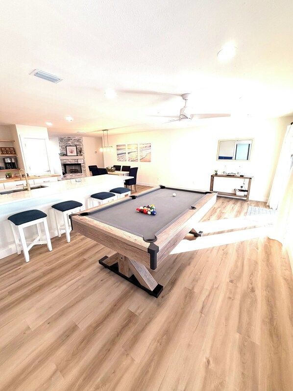 A pool table with balls, a dining area with chairs, and a kitchen area with a coffee machine. - Coastal Retreat with Pool, Games & Free Kayaks (Sebastian)