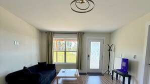 Ein Wohnzimmer mit einer Couch, einem Couchtisch und einem Fernseher auf einem Lowboard.